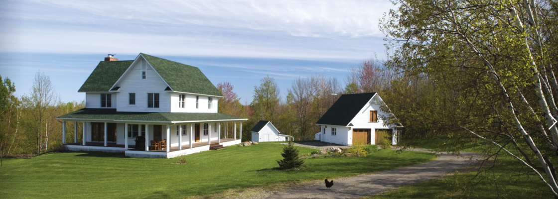 A large country house with a garage on the side of a hill