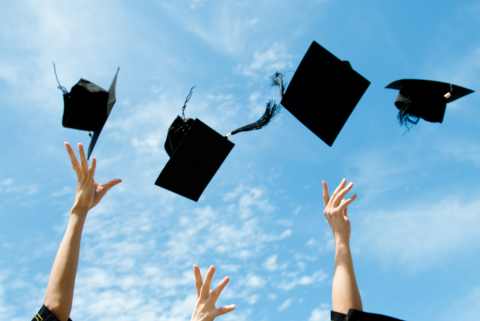 students throwing graduation caps